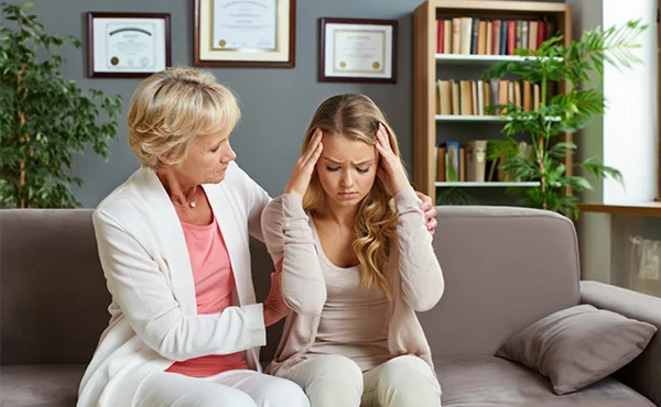 психолог держит за плечи пациента